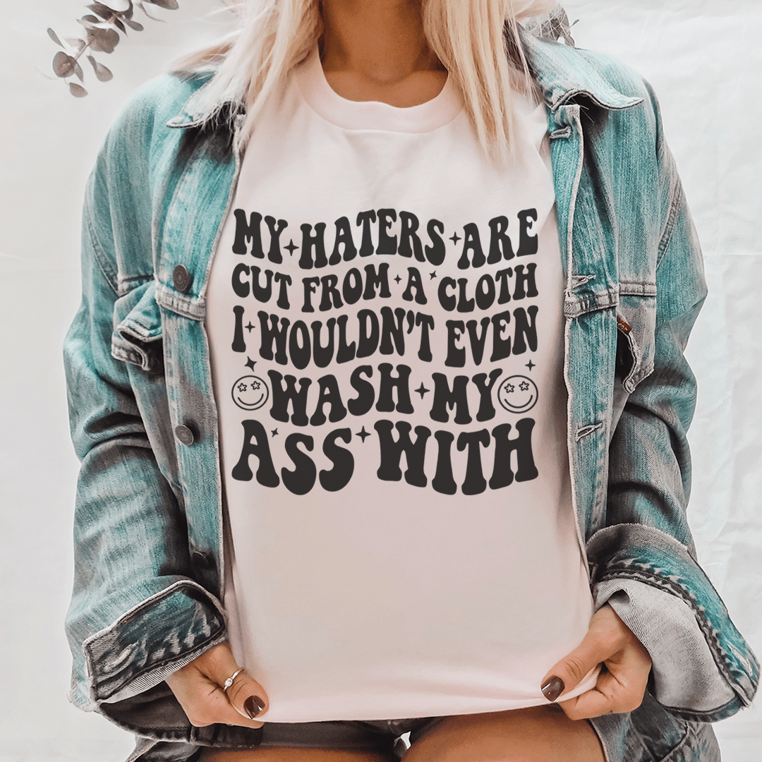 Pink cotton statement graphic tee shirt featuring bold "My haters are cut from a cloth" print.