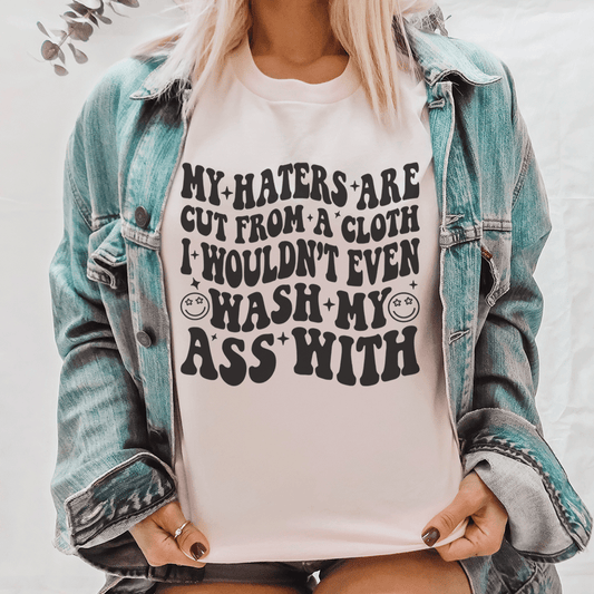 Pink cotton statement graphic tee shirt featuring bold "My haters are cut from a cloth" print.