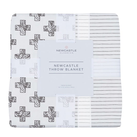 Folded bamboo muslin throw blanket in its band, printed with gray stamped crosses and thin dark pencil stripes