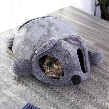 Tabby cat lying inside the grey mouse shaped cave bed.