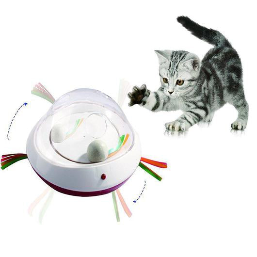 Silver tabby kitten swatting at the motion activated cat toy as its ribbon teasers spin and two balls sit under the dome