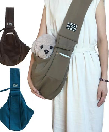 Person wearing a khaki pet sling with a small white dog, plus brown and teal options.