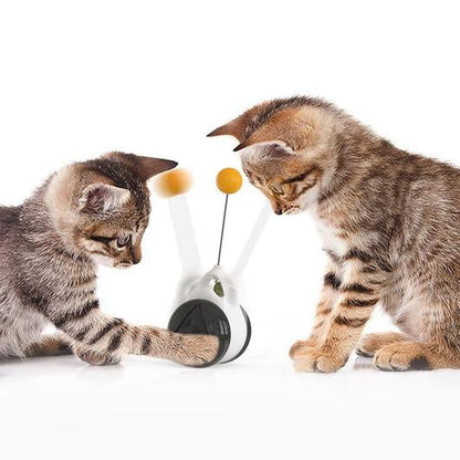 Two tabby kittens batting the orange ball on the spring wire of a white and dark gray self play cat toy