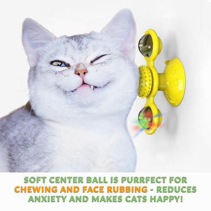 White cat winking as it rubs its face on a yellow suction cup windmill toy fixed to a wall