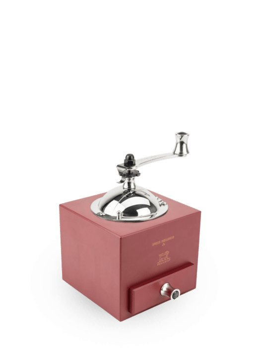 Box shaped pepper mill in a chili red finish, with a crank handle on top and a drawer below.