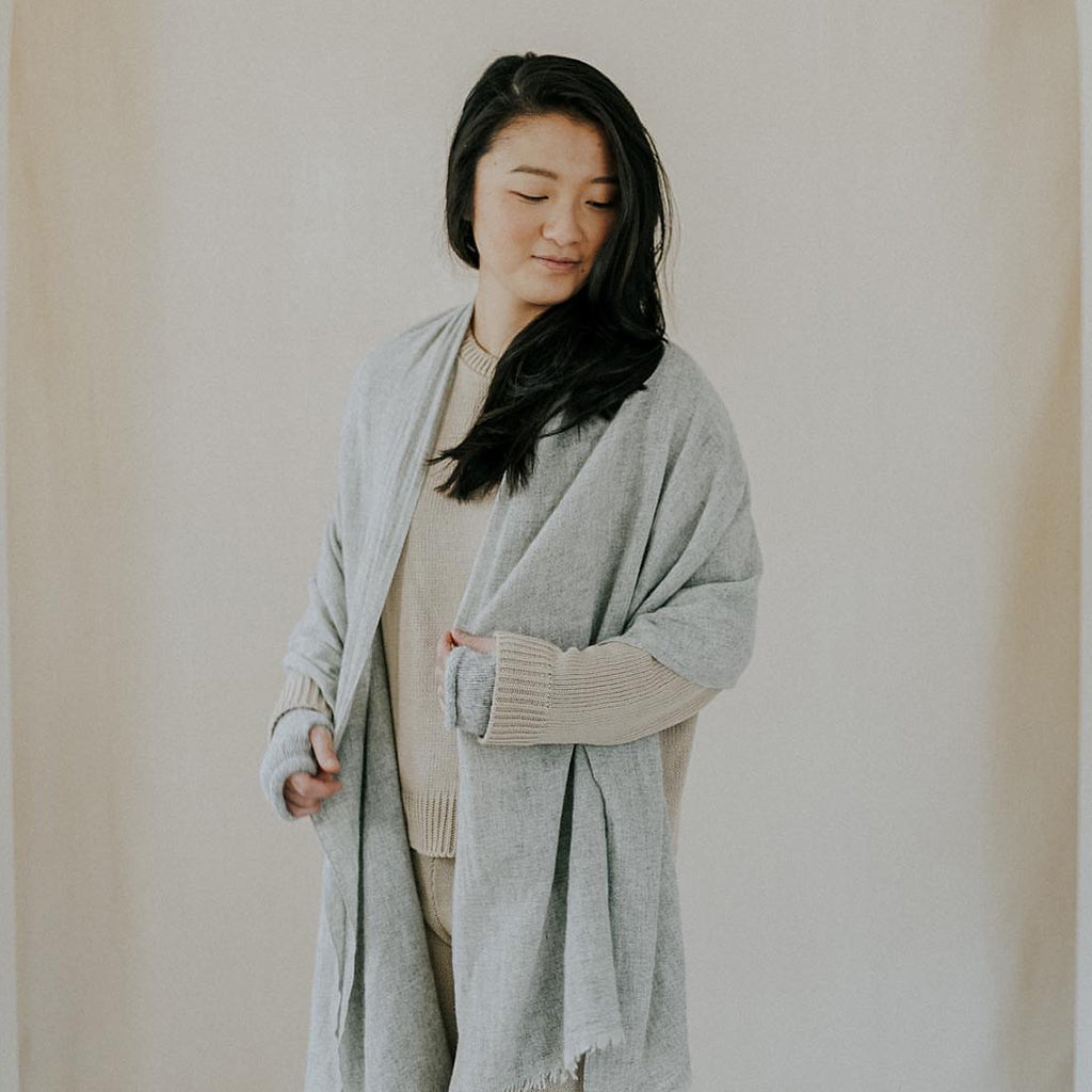Model wearing the heather gray scarf open over a sweater like a long wrap