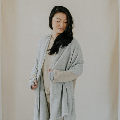 Model wearing the heather gray scarf open over a sweater like a long wrap