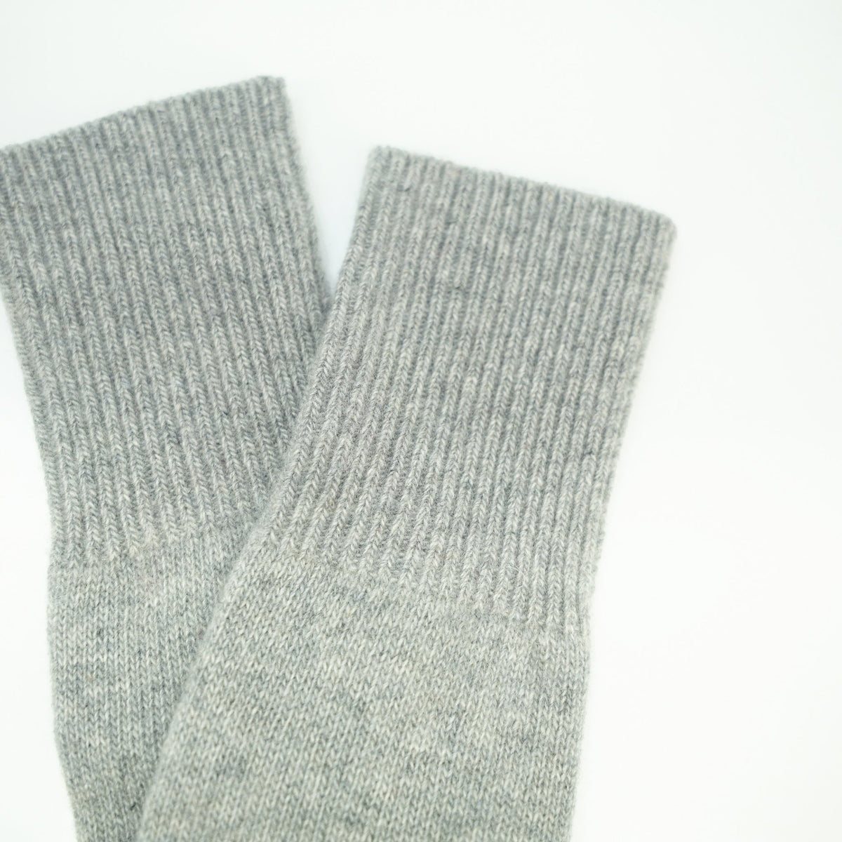 Close up of the ribbed cuffs on light gray cashmere fingerless gloves