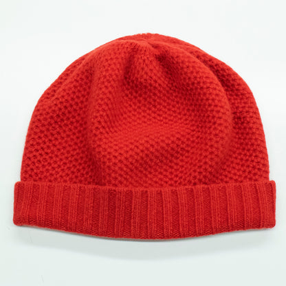Fire red cashmere beanie laid flat, honeycomb texture above a ribbed cuff
