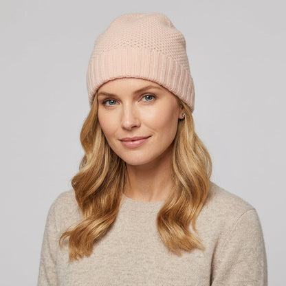 Rose quartz cashmere beanie on a model, a pale pink honeycomb knit with ribbed cuff
