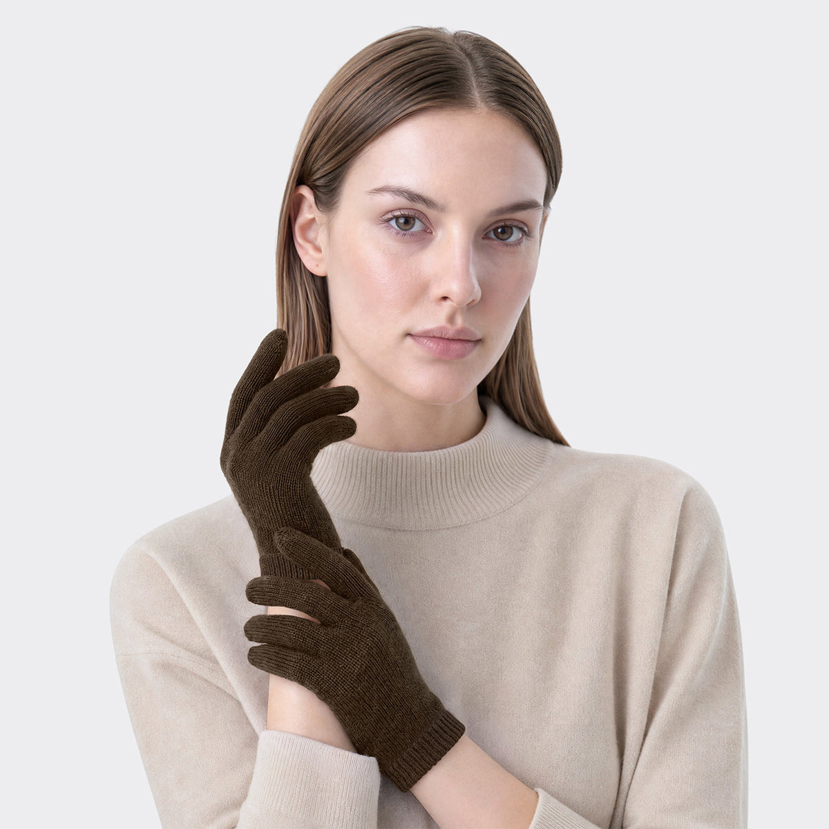 Model wearing chocolate brown cashmere gloves with a cream knit sweater