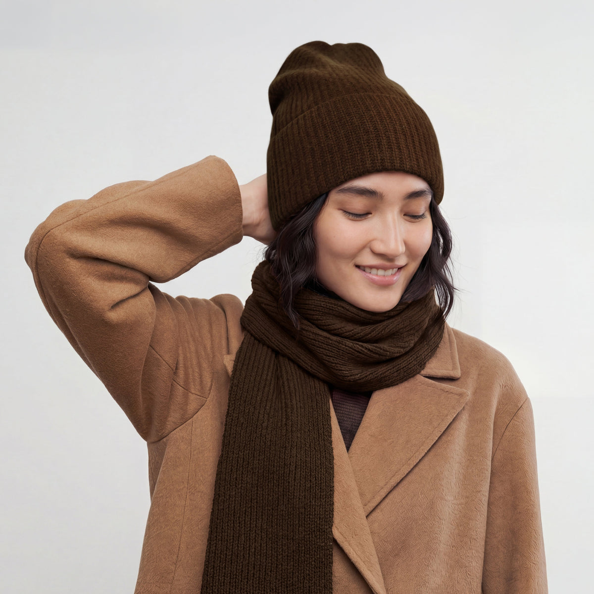 Model in the chocolate brown ribbed cashmere hat with a matching brown scarf and a camel coat