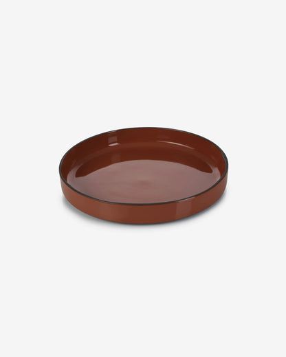 Cinnamon deep plate seen at an angle, showing the straight wall of its rim.