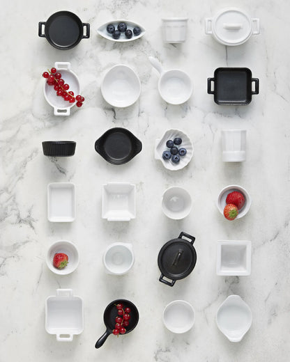 Overhead flat lay of the range in black and white, several pieces holding fruit.