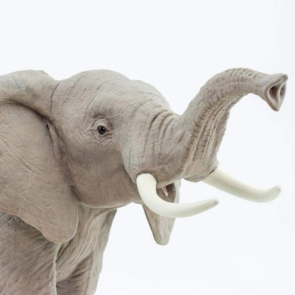 Close crop of the elephant figurine head, showing the wrinkled hide, tusks and raised trunk
