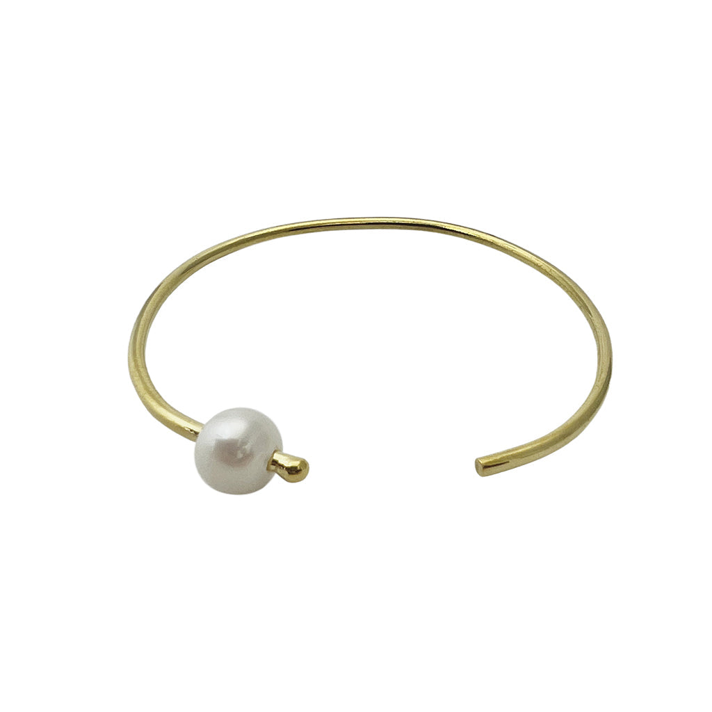 Freshwater pearl bangle bracelet on white, a slim open gold plated band with one pearl at the tip