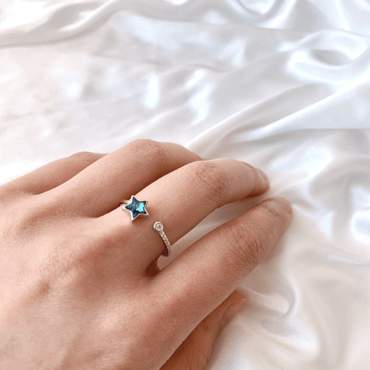 Adjustable star ring by Fashion Hut Jewelry featuring rainbow crystals and blue accents, showcasing its intricate design and sparkling details.