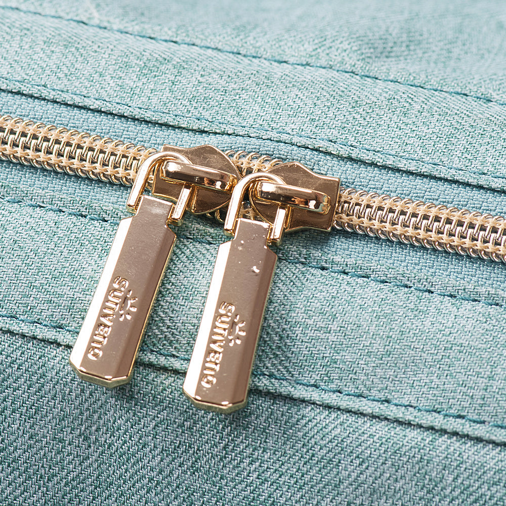 Close view of the paired gold zipper pulls on the diaper tote.