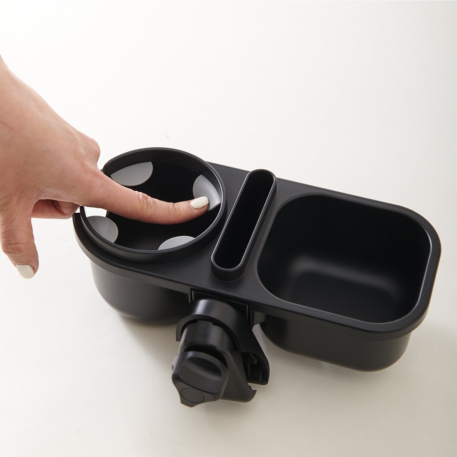 Hand pressing the tray to show the rotating clamp fitting underneath.
