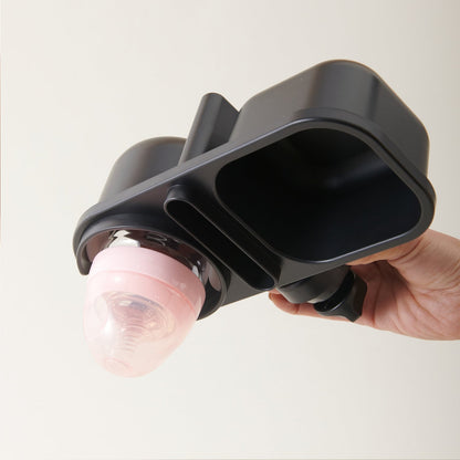 Hand holding the clamp with a baby bottle standing in the cup ring.