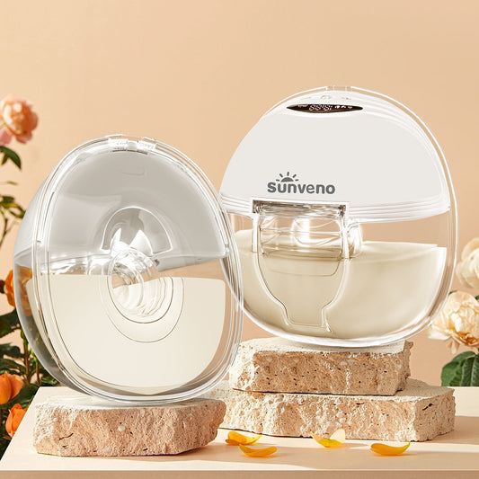 Two wearable breast pumps displayed on stone plinths, one holding expressed milk.