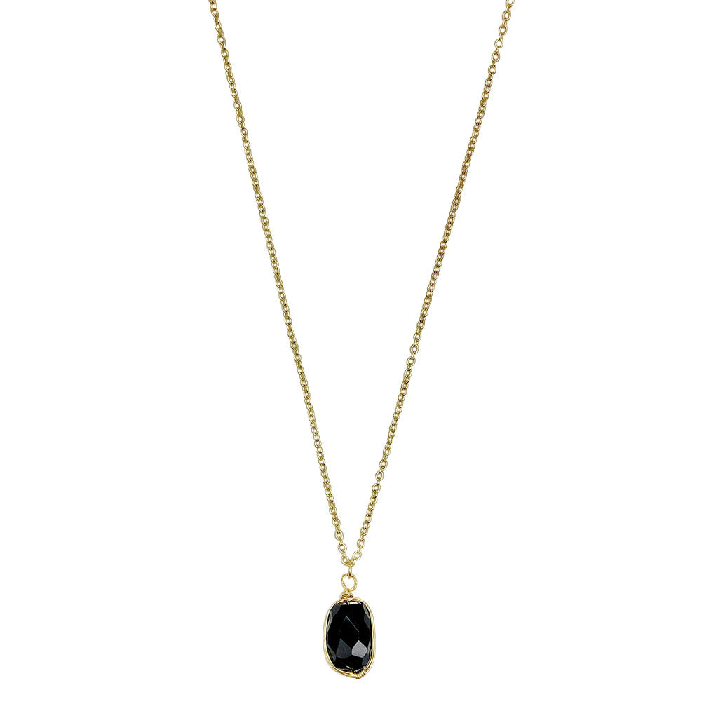 Black quartz pendant necklace on white, a faceted oval stone wrapped in brass on a fine chain
