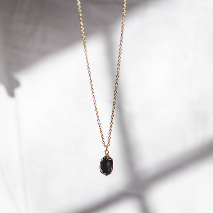 Black quartz pendant hanging in front of a soft window shadow