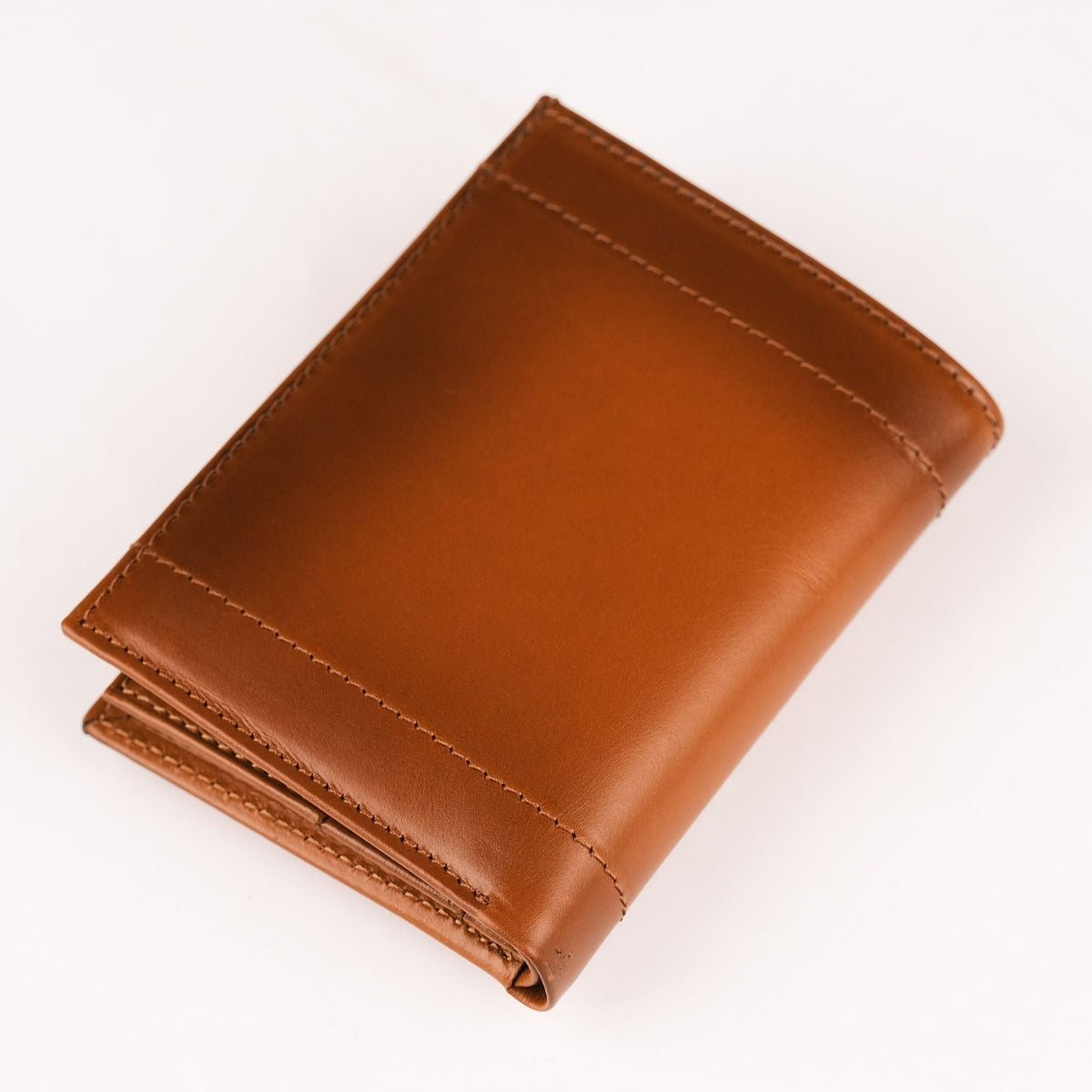 Back of the tan AirTag wallet, a smooth face with a stitched band across the lower edge