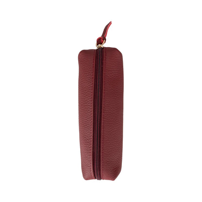 Maroon leather pencil case standing on end, the zip line running down its length