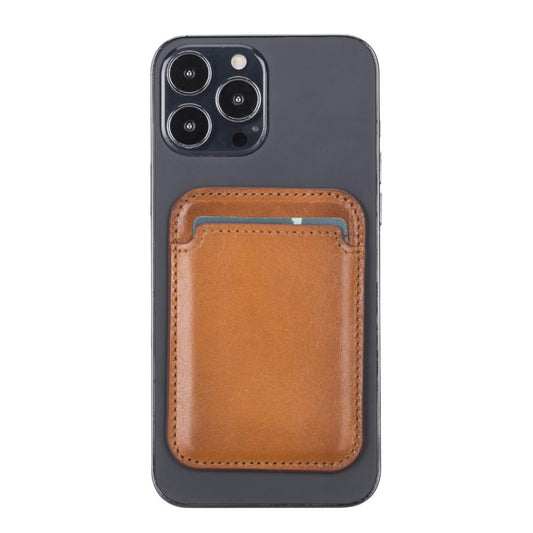 Magnetic leather card holder in tan attached to the back of a dark iPhone