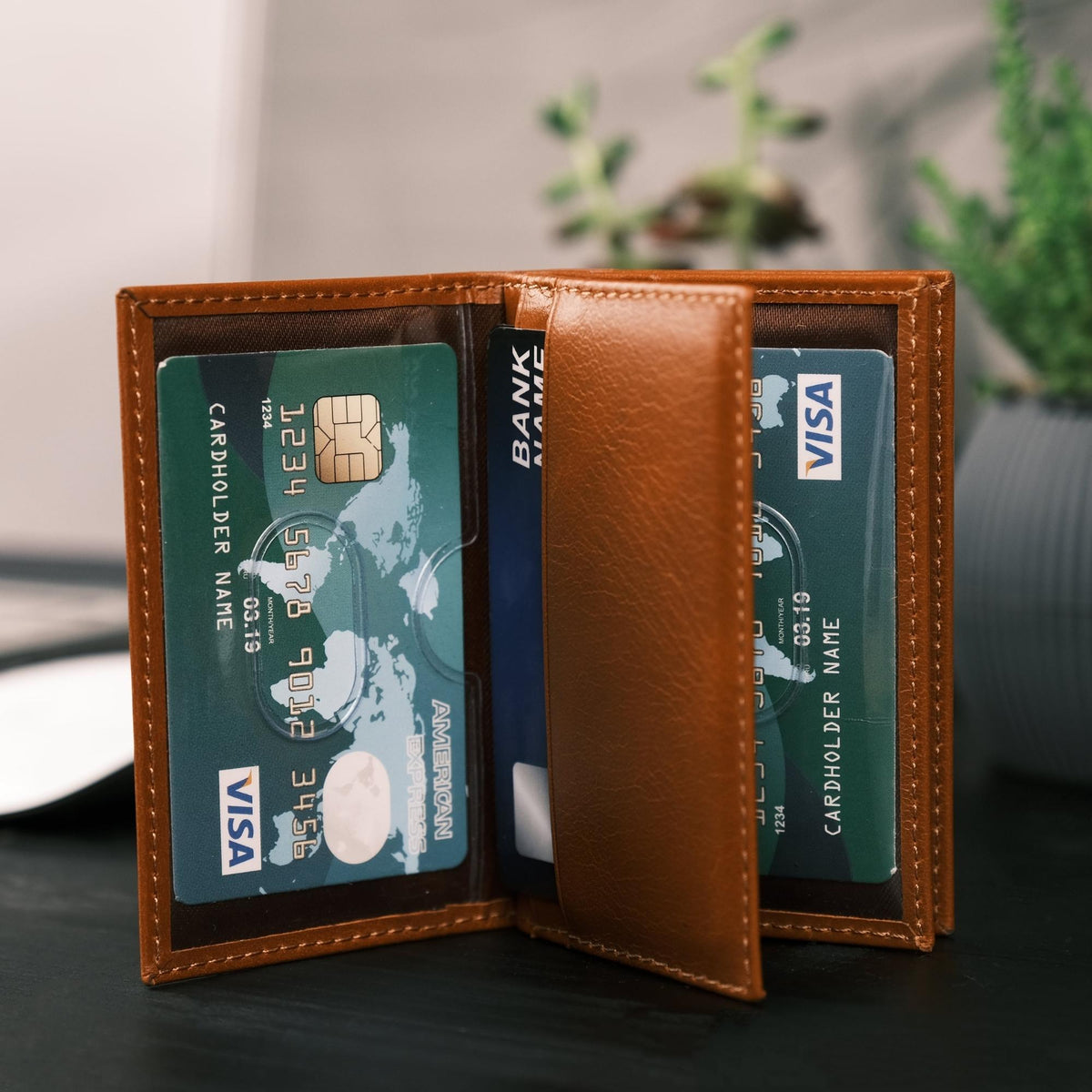 Tan leather card holder standing open, clear sleeves showing cards on both sides of a center pocket