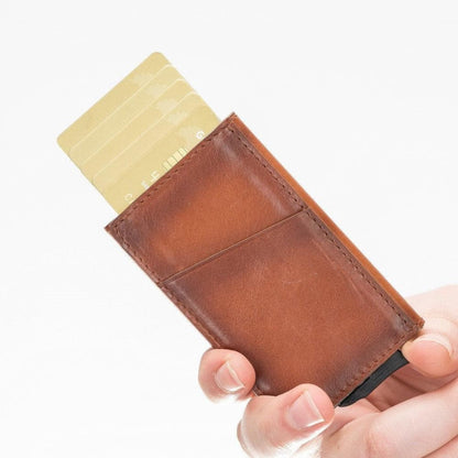 Hand pressing the lever of the tan pop up card holder, a card rising from the top