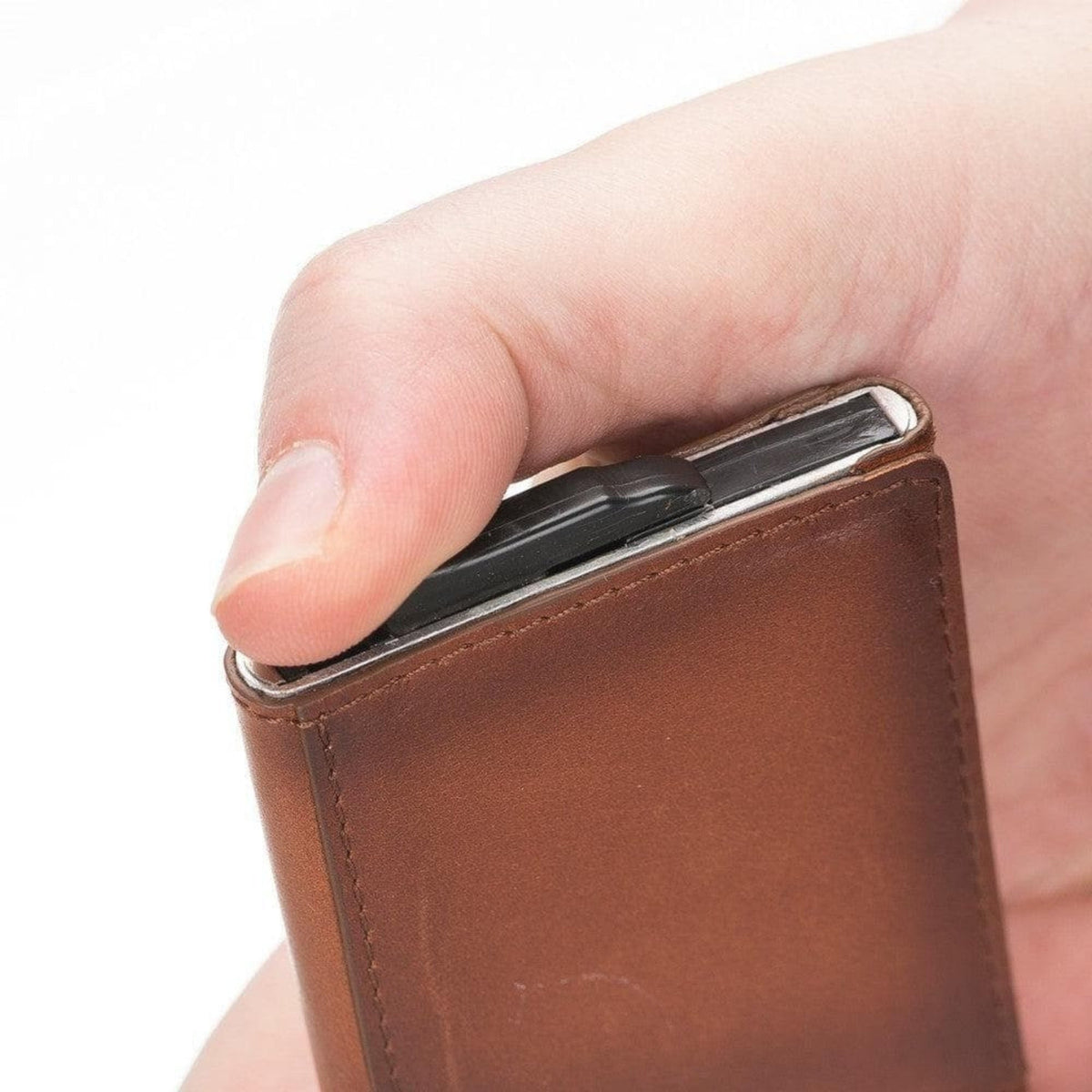 Close-up of a thumb on the release lever at the base of the tan pop up card holder