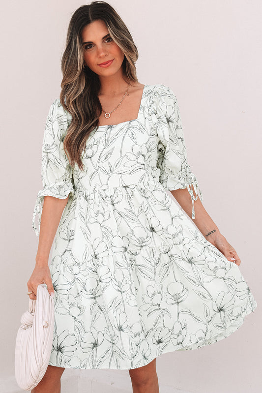 Ivory botanical print square neck dress with puff sleeves and a pink bag