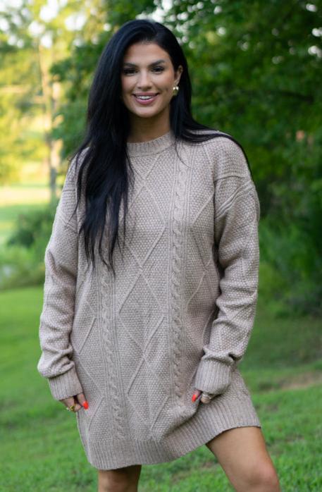 Taupe cable knit sweater dress, model smiling in a park