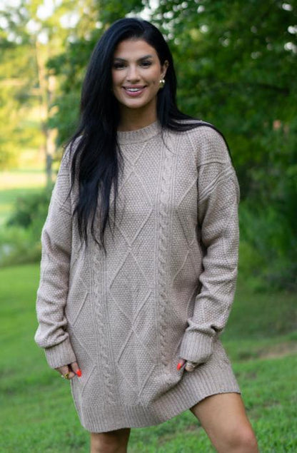 Taupe cable knit sweater dress, model smiling in a park