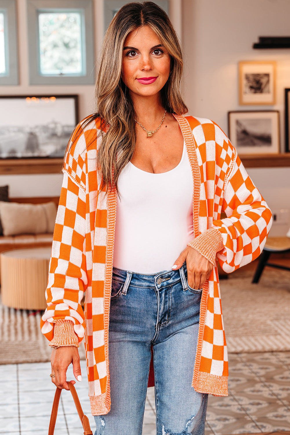 Orange and white checkered cardigan over a white tank and jeans, front view