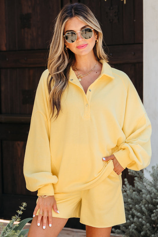 Pale yellow collared pullover and shorts set, model in sunglasses, front view