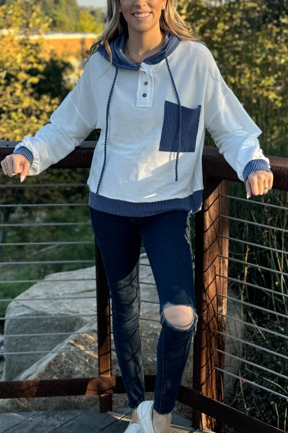 White and denim blue knit hoodie with a chest pocket and ripped jeans