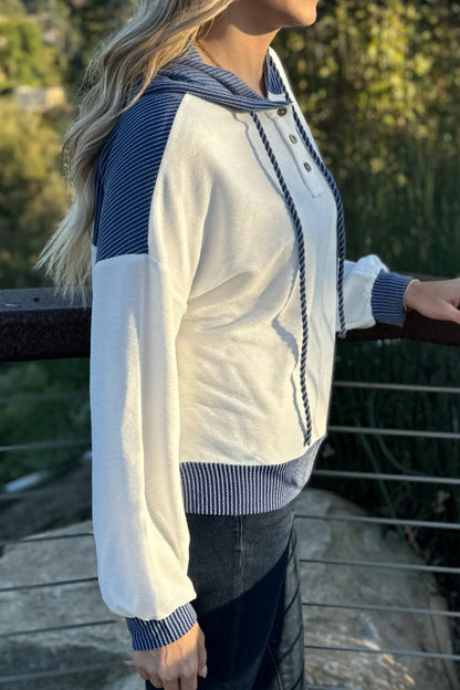 Side view of the white hoodie with blue sleeve panels