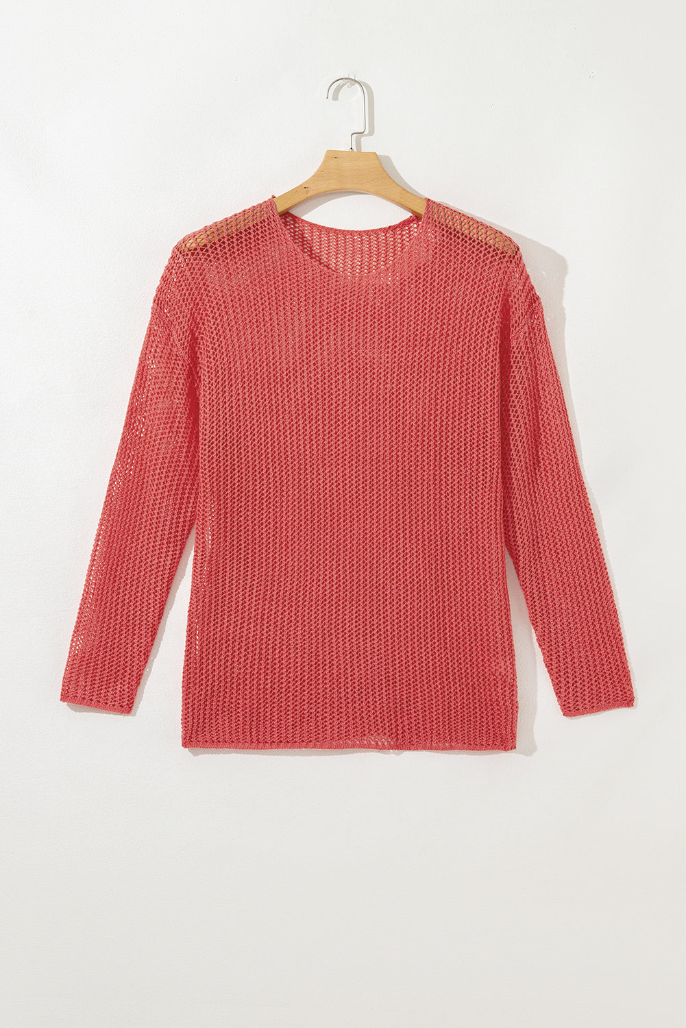 Coral crochet open-knit sweater on a hanger
