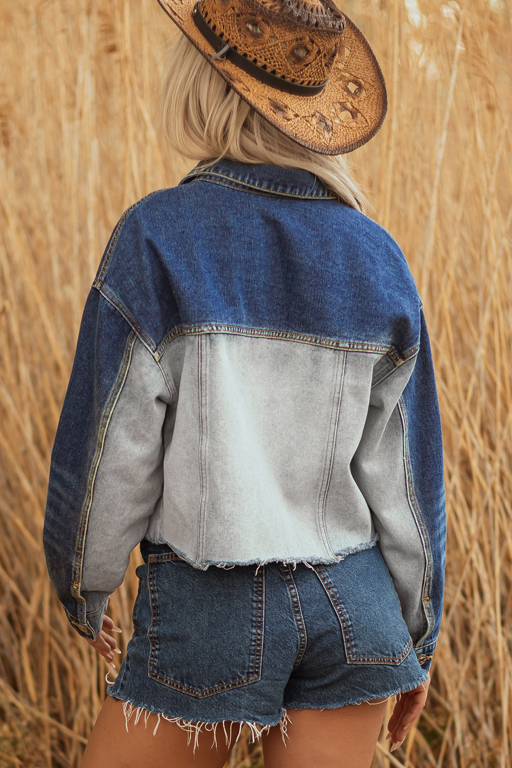 Back of the cropped denim jacket with a light wash panel and dark sleeves
