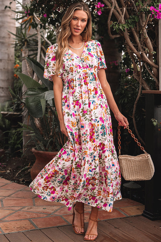 Pink and red floral maxi dress with flutter sleeves and a straw bag