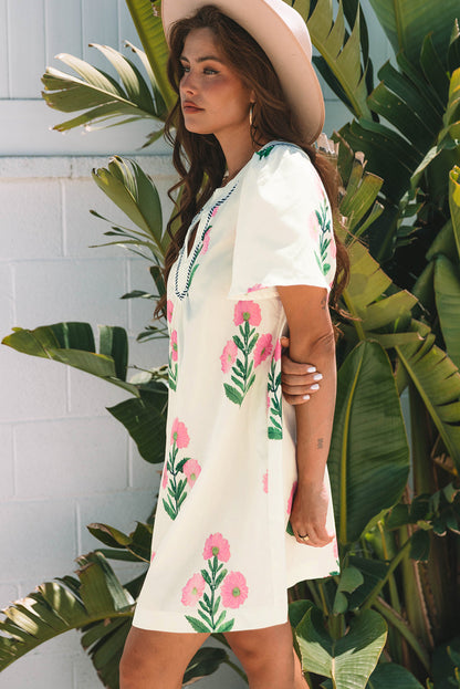Three-quarter view of the cream floral mini dress