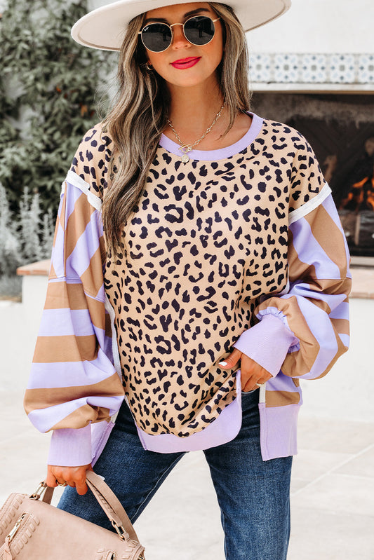 Leopard print sweatshirt with lavender and tan striped sleeves, model in a hat and sunglasses