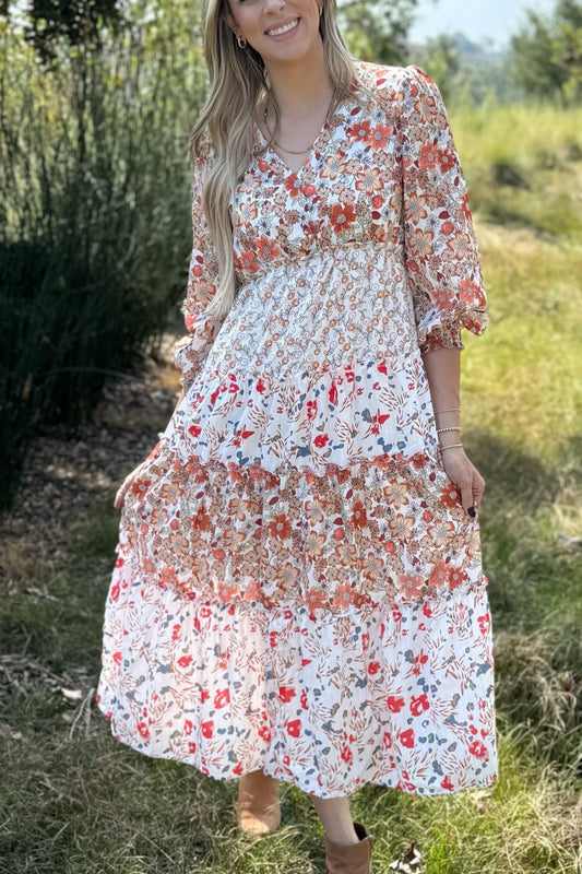 Mixed floral tiered midi dress with long sleeves in a field, front view