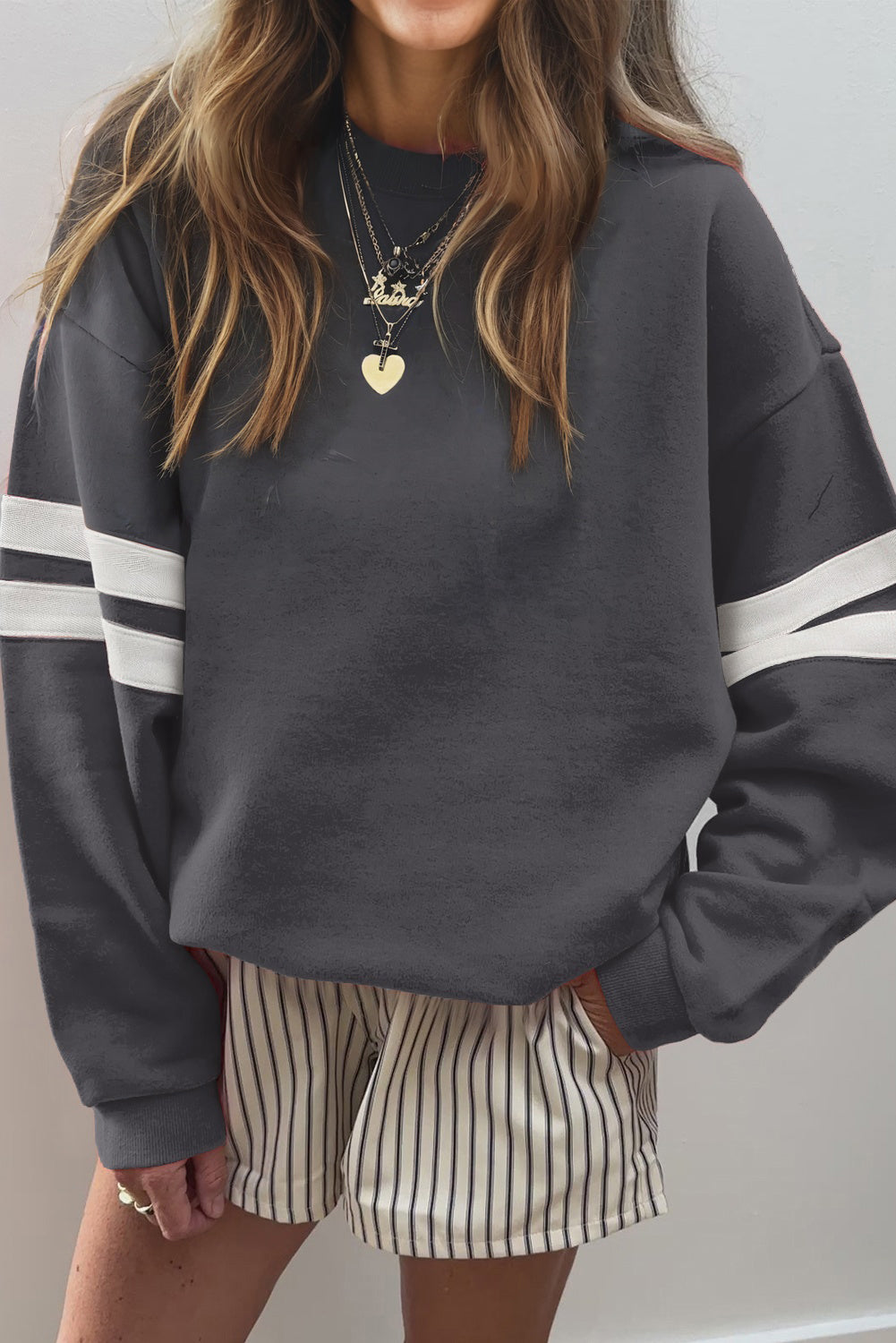 Dark gray oversized sweatshirt with white sleeve stripes and striped shorts