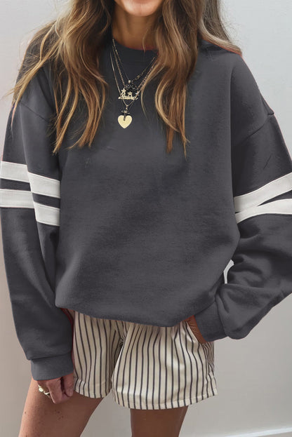 Dark gray oversized sweatshirt with white sleeve stripes and striped shorts