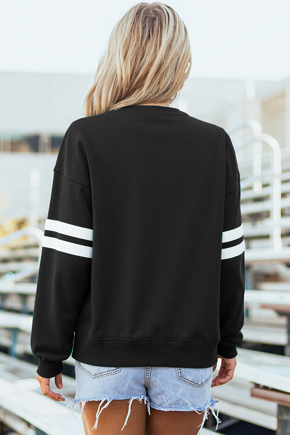 Back view of the black varsity stripe sweatshirt