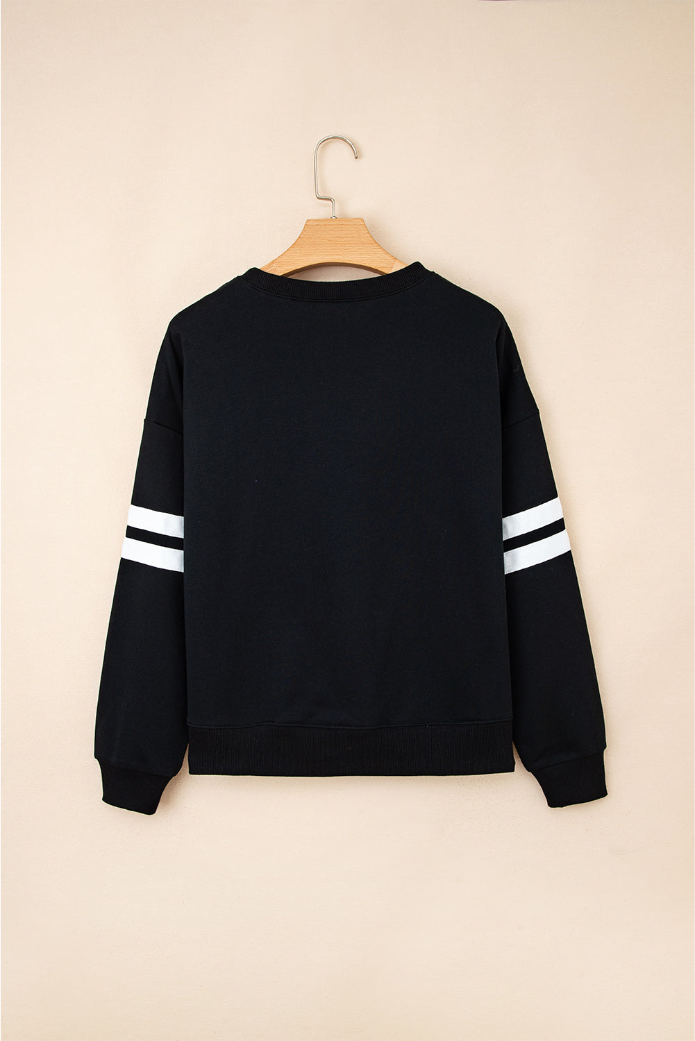 Black varsity stripe sweatshirt on a hanger, back view